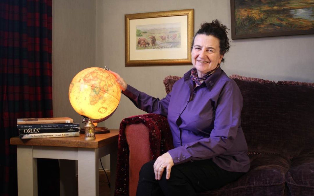 Marina sits beside her world globe