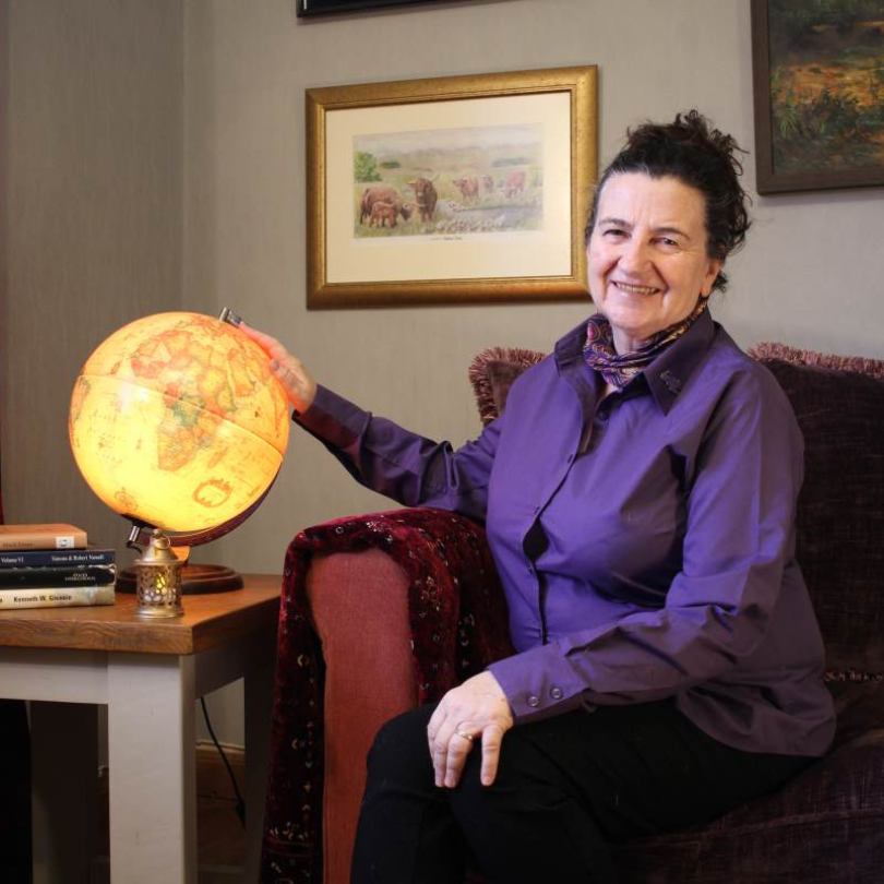 woman sitting hand on an illuminated world globe